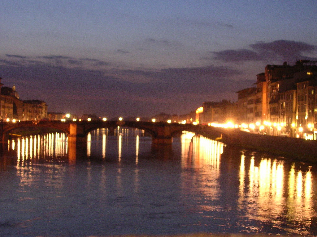 The Ponte Santa Trinita bridge over the Arno river, viewed from the Ponte Vecchio bridge, by night