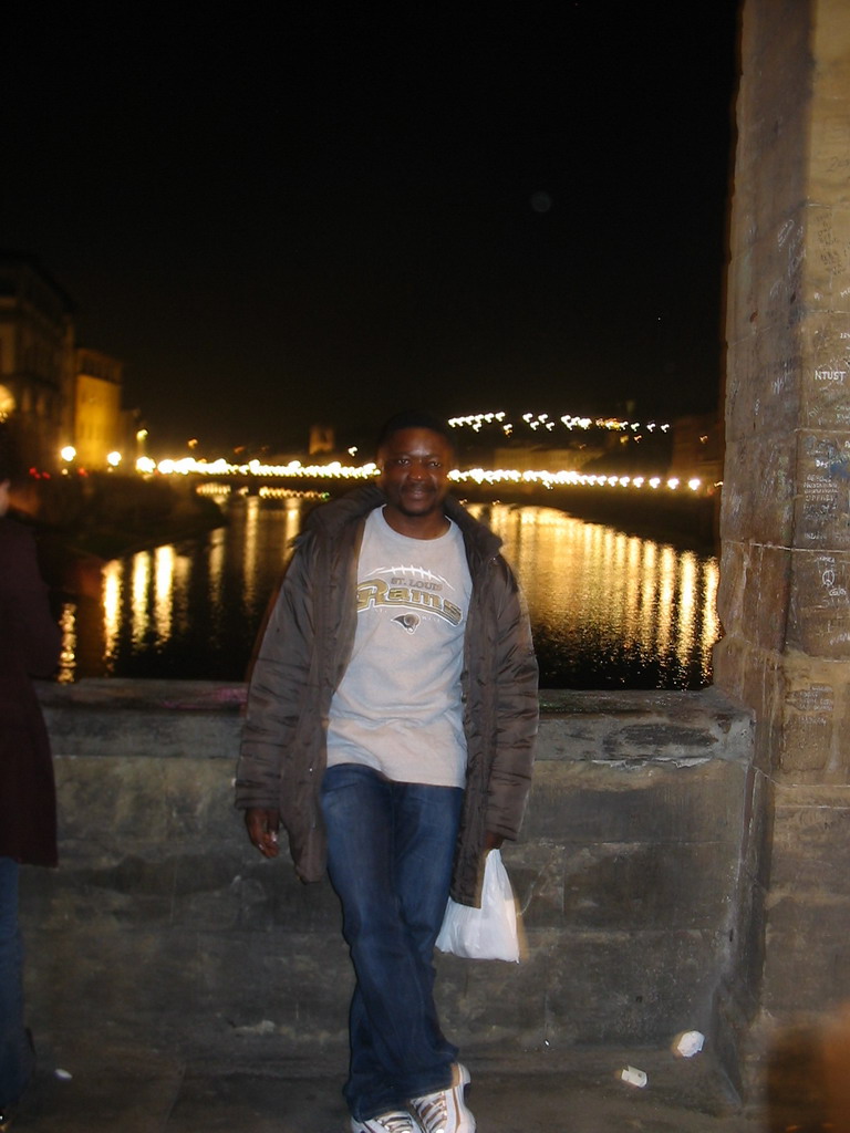 Miaomiao`s friend at the Ponte Vecchio bridge, with a view on the Ponte alle Grazie bridge over the Arno river, by night
