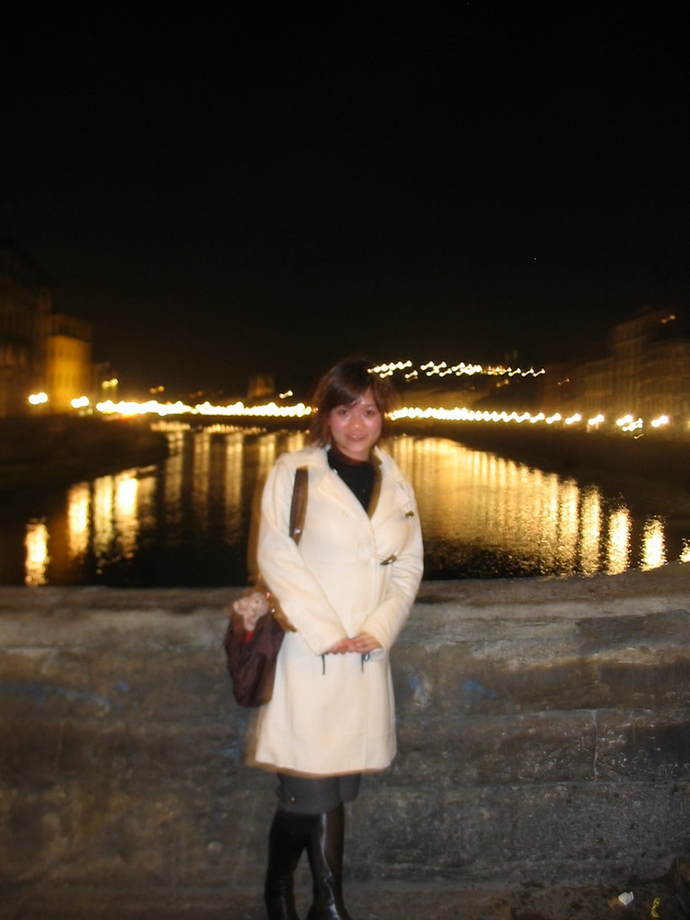 Miaomiao at the Ponte Vecchio bridge, with a view on the Ponte alle Grazie bridge over the Arno river, by night