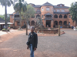 Our friend and a statue in front of the Foumban Royal Palace