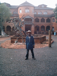 Our friend and a statue in front of the Foumban Royal Palace