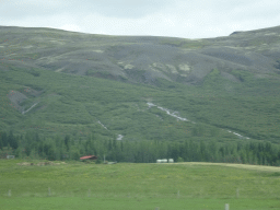 Farm, waterfalls and mountains, viewed from the rental car on the Laugarvatnsvegur road