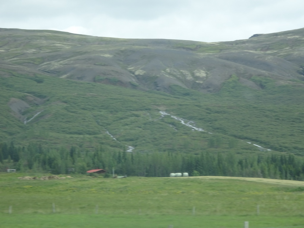 Farm, waterfalls and mountains, viewed from the rental car on the Laugarvatnsvegur road