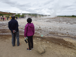 Miaomiao`s parents with the Strokkur geyser and other geysers at the Geysir geothermal area