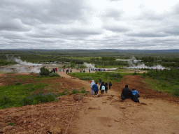 The Geysir geothermal area with the Konungshver, Geysir and Strokkur geysers and other geysers, viewed from the path to the Útsýnisskífa viewpoint