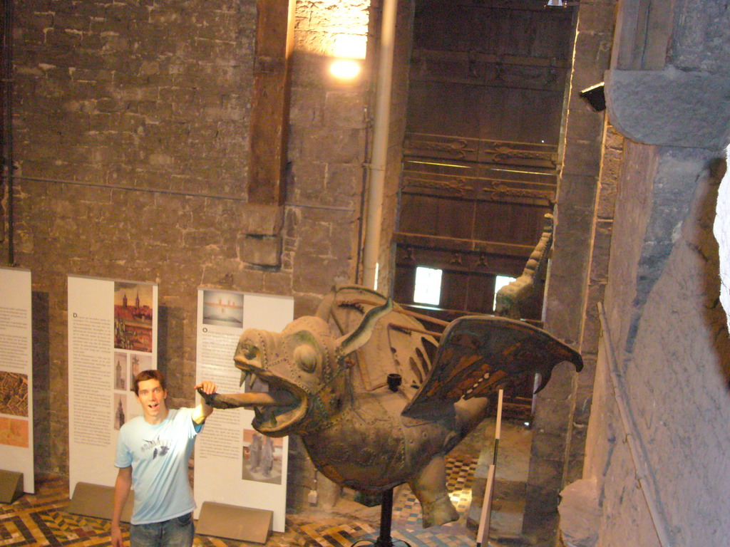 Tim with a dragon statue and gate at the Tower Keepers Room at the first floor of the Belfry of Ghent, viewed from the staircase to the second floor
