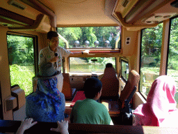 Zookeeper and tourists in the safari bus crossing a river at the Bali Safari & Marine Park