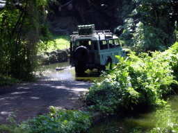 Safari jeep crossing a river at the Bali Safari & Marine Park, viewed from the safari bus