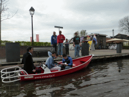 Tourists in a boat on the canal along the Dominee T.O. Hylkemaweg street, viewed from our tour boat