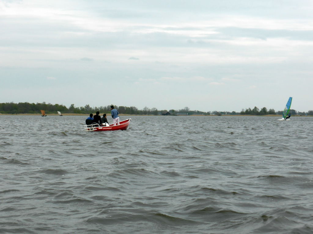 Boats with tourists and a surfer on the Bovenwijde lake, viewed from our tour boat