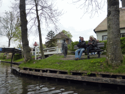Statue of the actor Albert Mol from the movie `Fanfare`, houses and a bridge over the Binnenpad canal, viewed from our tour boat