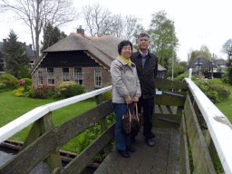 Miaomiao`s parents at a bridge over the Binnenpad canal, with a view on a house with a camel roof