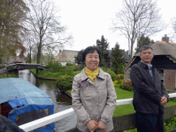 Miaomiao`s parents at a bridge over the Binnenpad canal, with a view on a boat, houses and bridges over the Binnenpad canal