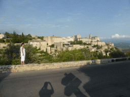 Miaomiao at the crossing of the Route de Cavaillon road and the Route de Senanque road, with a view on the west side of town with the Château de Gordes castle and the Église Saint Firmin church