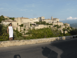 Miaomiao at the crossing of the Route de Cavaillon road and the Route de Senanque road, with a view on the southwest side of town with the Château de Gordes castle and the Église Saint Firmin church