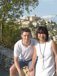 Tim and Miaomiao at a parking place next to the Route de Cavaillon, with a view on the southwest side of town with the Château de Gordes castle and the Église Saint Firmin church