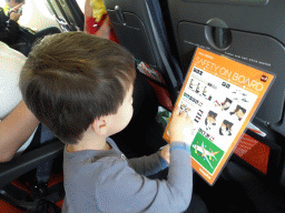 Max reading the safety instructions at the airplane to Amsterdam
