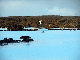 Man on a bridge at the water just outside the Blue Lagoon geothermal spa