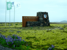 Sign and flags of Grindavík, viewed from the rental car on the Grindavíkurvegur road