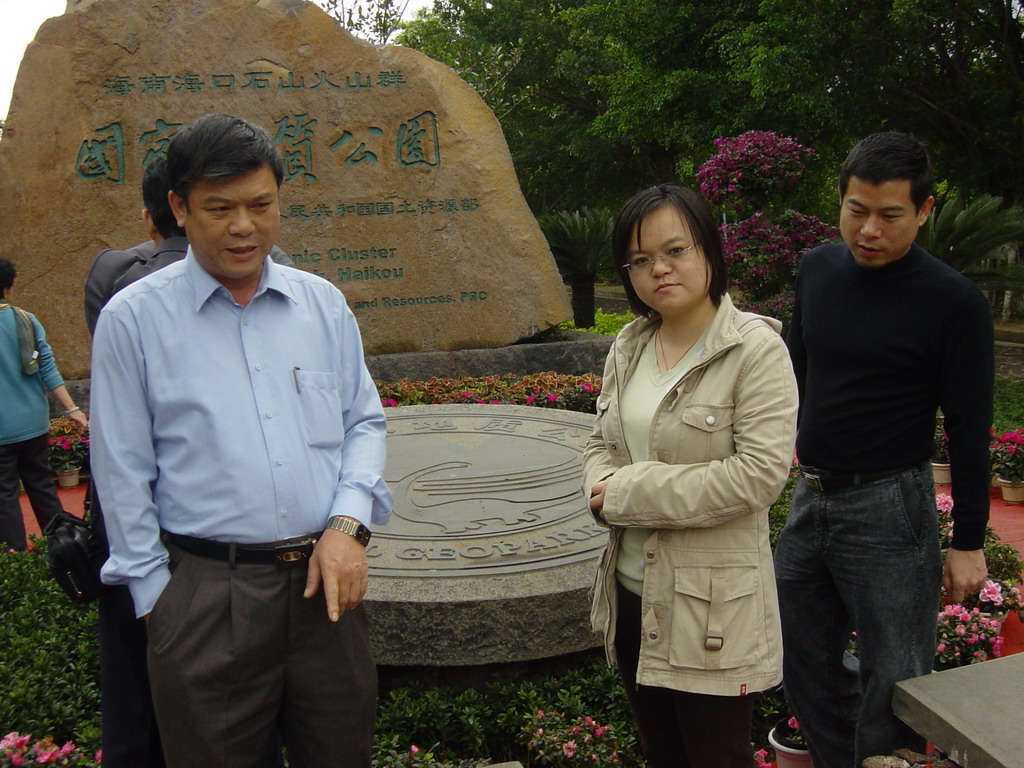 Miaomiao`s father and sister in front of a rock with inscriptions at the entrance to the Hainan Volcano Park