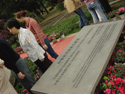 Miaomiao`s mother at a stone with inscription at the entrance to the Hainan Volcano Park