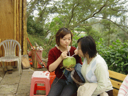 Miaomiao and her sister drinking from a coconut at the Mt. Fengluling volcano crater at the Hainan Volcano Park