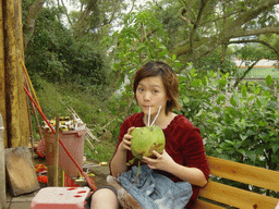 Miaomiao drinking from a coconut at the Mt. Fengluling volcano crater at the Hainan Volcano Park