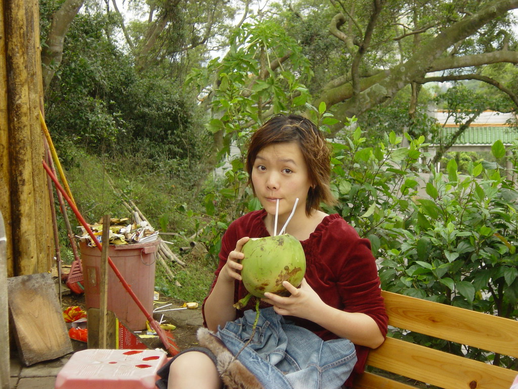 Miaomiao drinking from a coconut at the Mt. Fengluling volcano crater at the Hainan Volcano Park