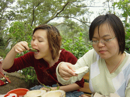 Miaomiao and her sister eating from a coconut at the Mt. Fengluling volcano crater at the Hainan Volcano Park