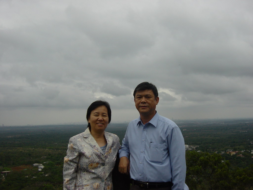 Miaomiao`s parents at the top of the Mt. Fengluling volcano crater at the Hainan Volcano Park, with a view on the surrounding area