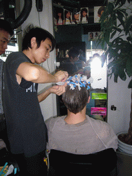 Tim getting a haircut at a barber in the city center