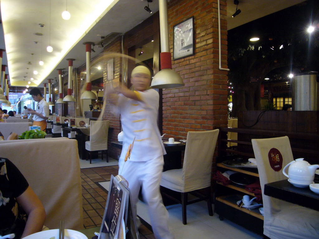 Cook preparing noodles, in a restaurant in the center of the city