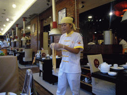 Cook preparing noodles, in a restaurant in the center of the city