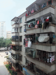 Apartment building in the city center with laundry drying at the balconies, viewed from a department store