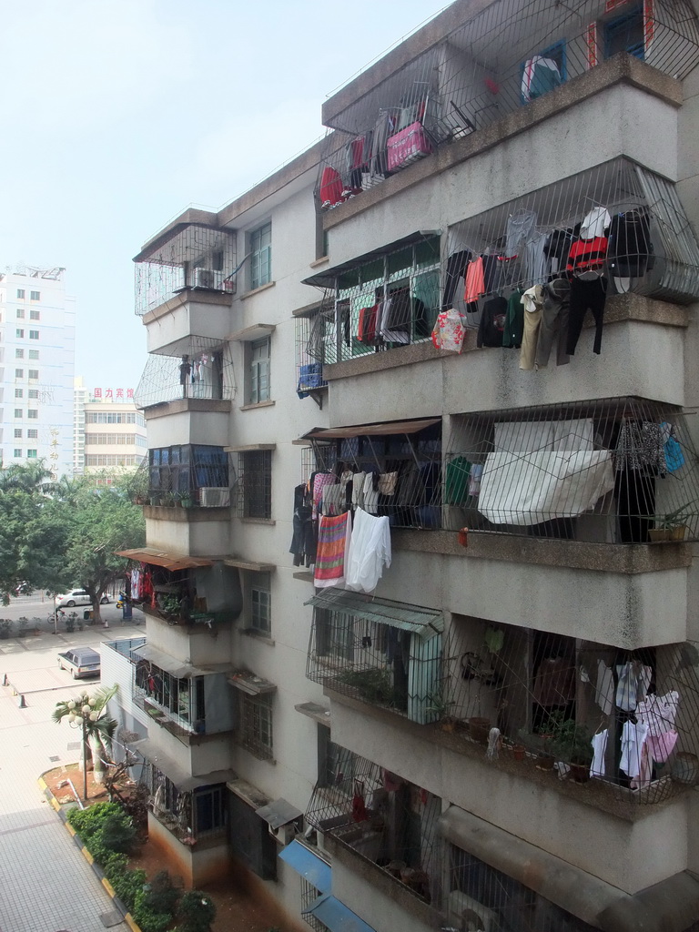 Apartment building in the city center with laundry drying at the balconies, viewed from a department store
