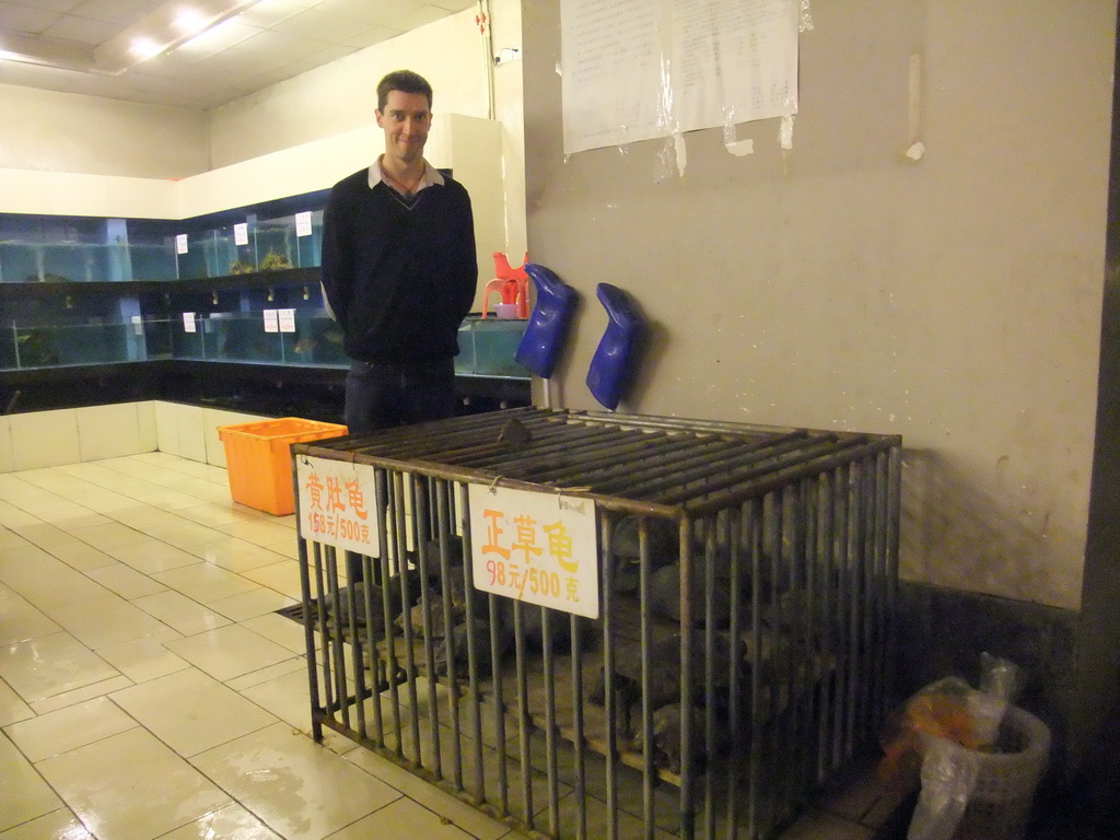 Tim at a cage with turtles in a restaurant to the south of the city center
