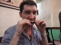 Tim eating snake meat in a restaurant at the city center