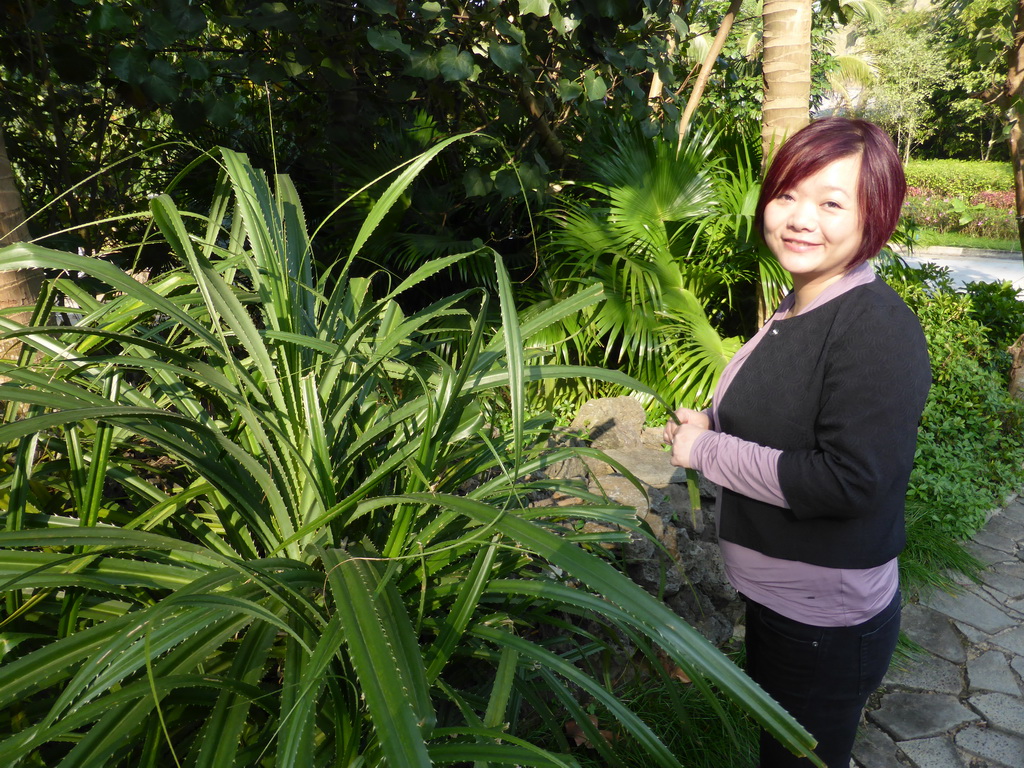 Miaomiao with a plant at the Mission Hills Golf Resort Haikou