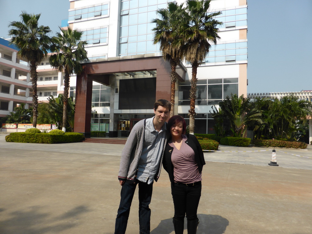 Tim and Miaomiao in front of the central building of the Hainan Overseas Chinese Middle School
