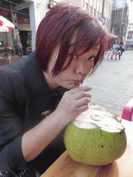 Miaomiao drinking from a coconut at a terrace at Zhongshan Road