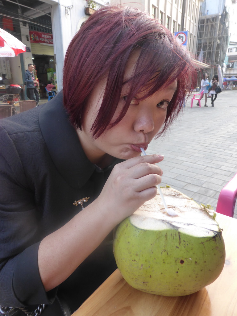 Miaomiao drinking from a coconut at a terrace at Zhongshan Road