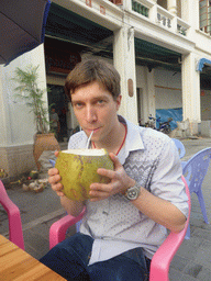 Tim drinking from a coconut at a terrace at Zhongshan Road