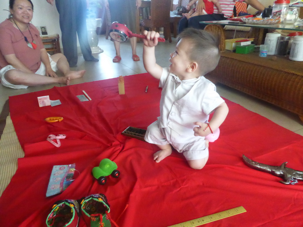 Miaomiao and Max during the Zhuazhou ceremony for Max`s first birthday in the apartment of Miaomiao`s parents