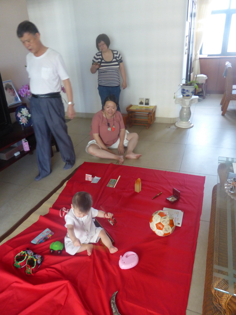 Miaomiao, Max and Miaomiao`s family during the Zhuazhou ceremony for Max`s first birthday in the apartment of Miaomiao`s parents