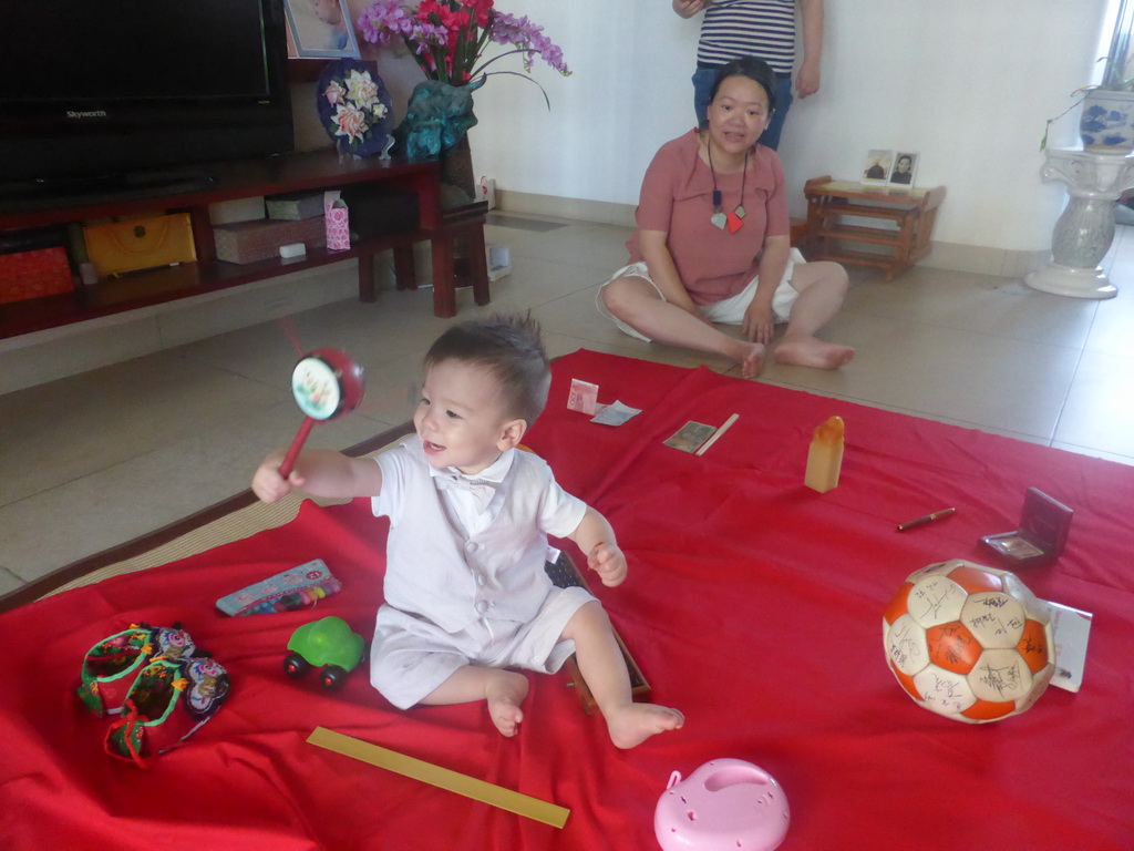 Miaomiao and Max during the Zhuazhou ceremony for Max`s first birthday in the apartment of Miaomiao`s parents