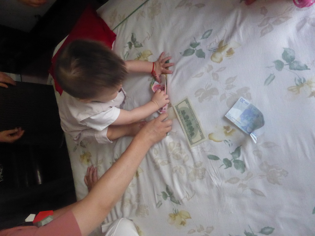 Max during the Zhuazhou ceremony for his first birthday in the apartment of Miaomiao`s parents