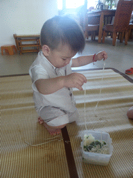 Max eating noodles for his first birthday in the apartment of Miaomiao`s parents