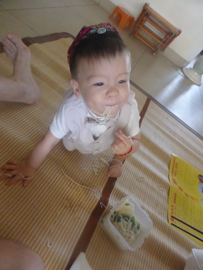 Max eating noodles for his first birthday in the apartment of Miaomiao`s parents