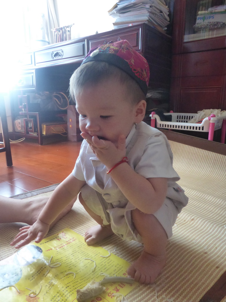 Max eating noodles for his first birthday in the apartment of Miaomiao`s parents