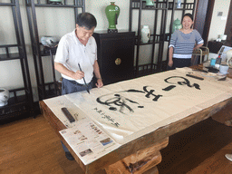 Miaomiao and Miaomiao`s father doing calligraphy at our lunch restaurant at the crossing of Binhai Avenue and Changtong Road